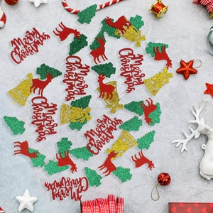 Macro shot of red reindeer and green glitter tree confetti for DIY Christmas party decor