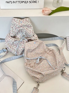 Floral canvas drawstring backpack with blue checkered straps in a minimalist aesthetic