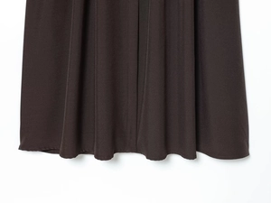 Detail of chocolate brown midi dress hem showing premium fabric texture and neat stitching