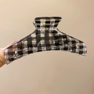 Close-up of black and white checkered acrylic claw clip with strong interlocking teeth