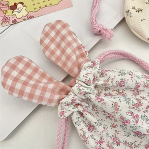 Close-up of pink floral drawstring storage bag with cute bunny ears and cotton texture