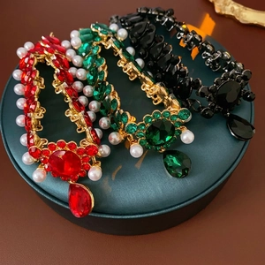 Vintage style necklaces with rhinestones and pearls displayed on emerald jewelry stands