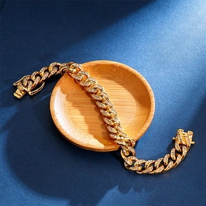 Dettaglio di un bracciale a maglia cubana hip hop placcato oro con strass scintillanti