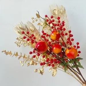Close-up of artificial Christmas branch with red berries and golden hollow feather leaves