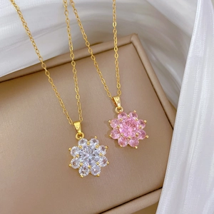 Close-up of titanium steel necklaces with sparkling pink and white zircon flower pendants