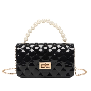 Glossy black quilted jelly bag with white pearl handle and gold clasp on white backdrop