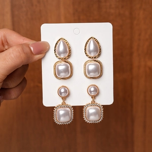 Detail of vintage gold pearl earring set with rhinestone square and waterdrop studs