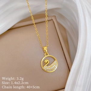 Detail of gold swan circle pendant with small diamonds on beige display card with silk