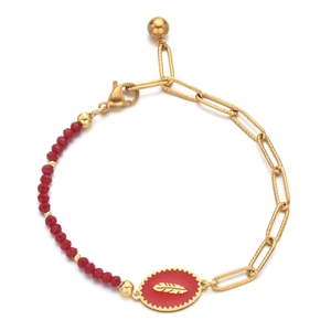 Detail view of gold paperclip chain and red bead bracelet with enamel feather charm