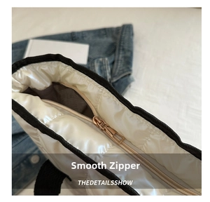 Detail of smooth metallic rose gold zipper on white quilted puffer space cotton tote bag