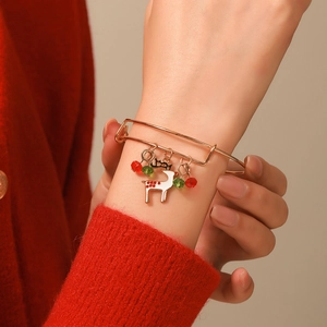 Detail of Christmas reindeer bangle with red and green beads on a gold-plated adjustable band