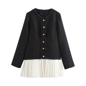 Dettaglio del corpetto in tweed nero con bottoni dorati e orlo a pieghe bianco