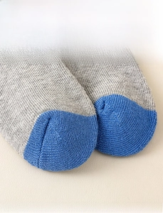 Detailed close-up of seamless toe stitching on gray and blue knit thermal socks