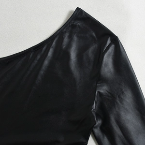 Détail de la robe moulante en similicuir noir avec col asymétrique et texture brillante