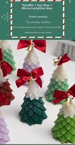 Detailed view of tree-shaped scented candles with snow coating and red ribbon bows