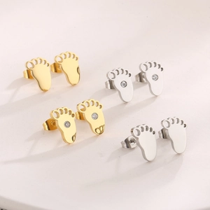 Close-up of paw-shaped stud earrings in gold and silver finishes with zircon stones
