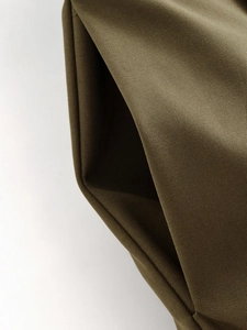 Detailed macro view of olive green twill fabric showing high-quality texture and stitching