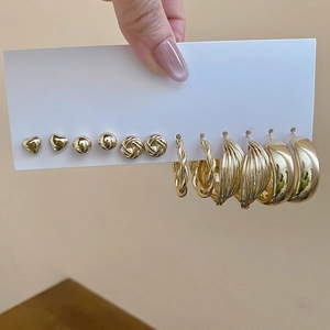 Detailed view of 6-pair gold earring set featuring heart studs and textured metal hoops