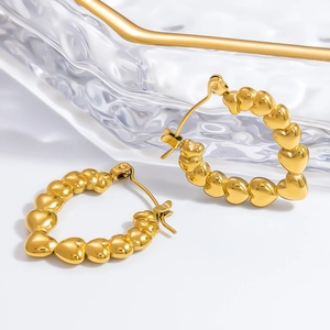Detailed close-up of 18k gold-plated stainless steel hoop earrings with heart-shaped links