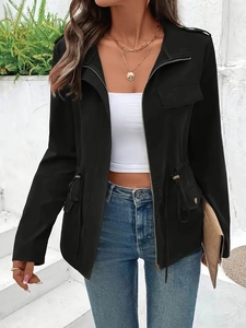 Detail einer schwarzen Jacke mit Tunnelzug an der Taille, Reißverschluss und Revers