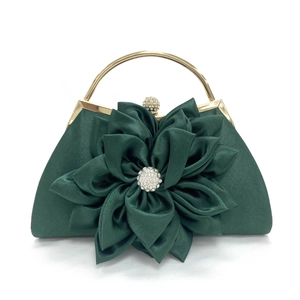 Detalle de bolso clutch de satén verde oscuro con flor de tela artesanal y asa dorada