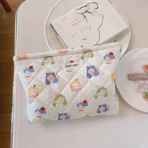Close-up of quilted floral cosmetic bag featuring cartoon girls and Simple Wish label