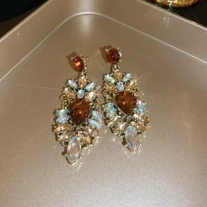 Macro view of vintage gold-tone earrings with amber droplets and sparkling crystals