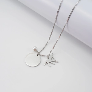 Détail du pendentif licorne argenté avec perle et médaille ronde sur une chaîne