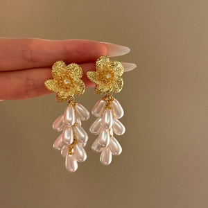 Elegant gold flower drop earrings with white teardrop pearls and shimmering zircon accents