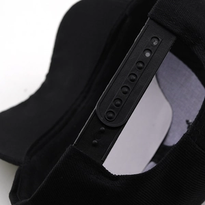 Detailed macro view of black baseball cap with adjustable plastic snapback closure