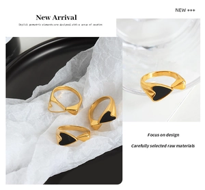 Detail of 18K gold-plated double heart ring featuring elegant black and white enamel finish