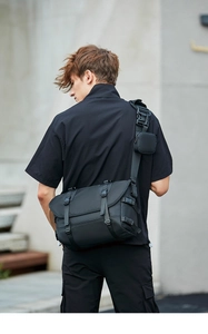 Detail of black techwear messenger bag with adjustable buckles and shoulder strap pouch