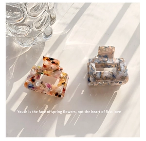 Close-up of square acetate hair claws with marble floral pattern and cutout design