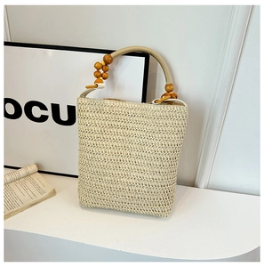 Detail of straw woven bag handle with decorative wooden beads and fabric wrapping texture