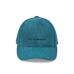 Detail view of NOT INTERESTED embroidery on corduroy fabric texture baseball cap