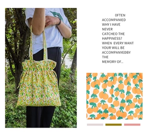 Detalle del bolso tote de lona con estampado floral, cordón ajustable y textura de tela