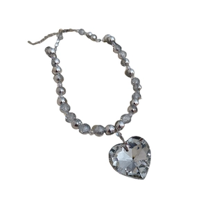 Minimalist silver beaded necklace featuring a large multifaceted heart crystal pendant