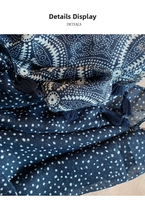 Detailed macro view of navy blue cotton scarf featuring white polka dots and fringe trim