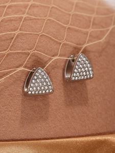 Macro shot of silver stainless steel triangular earrings with pavé cubic zirconia