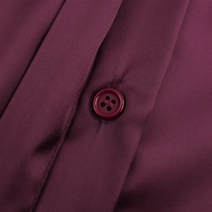 Close-up of elegant wine red satin shirt featuring metallic button and smooth silk texture