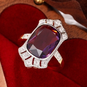 Luxurious rectangular purple gemstone ring with diamond halo in a red velvet heart box