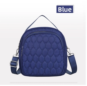 Detail of blue quilted nylon bag with smooth zipper and adjustable wide shoulder strap