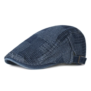 Détail de la boucle métallique réglable et texture patchwork en denim bleu du béret