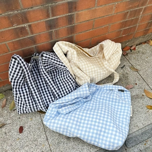 Detailed view of large canvas tote bags in black, beige, and blue plaid texture patterns