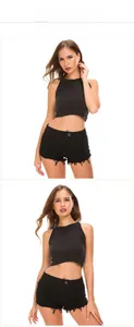 Detail of high waisted black denim shorts with ripped edges and frayed hem for women