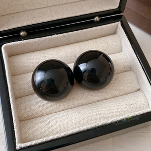 Nahaufnahme von polierten schwarzen Onyx-Ohrringen in einer luxuriösen Schmuckschatulle