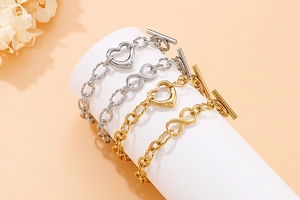 Detailed close-up of heart and infinity charm bracelets with OT toggle on a display stand