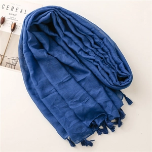 Detail of dark blue scarf featuring shimmering metallic threads and handcrafted fringe trim