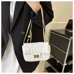 Detail view of the white V-quilted faux leather crossbody bag with elegant gold chain strap
