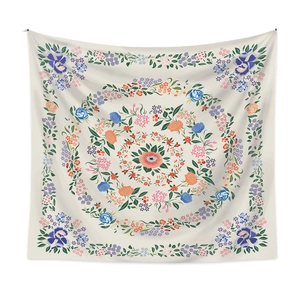 Close-up of vibrant mandala tapestry with detailed pink flowers and green leaves pattern